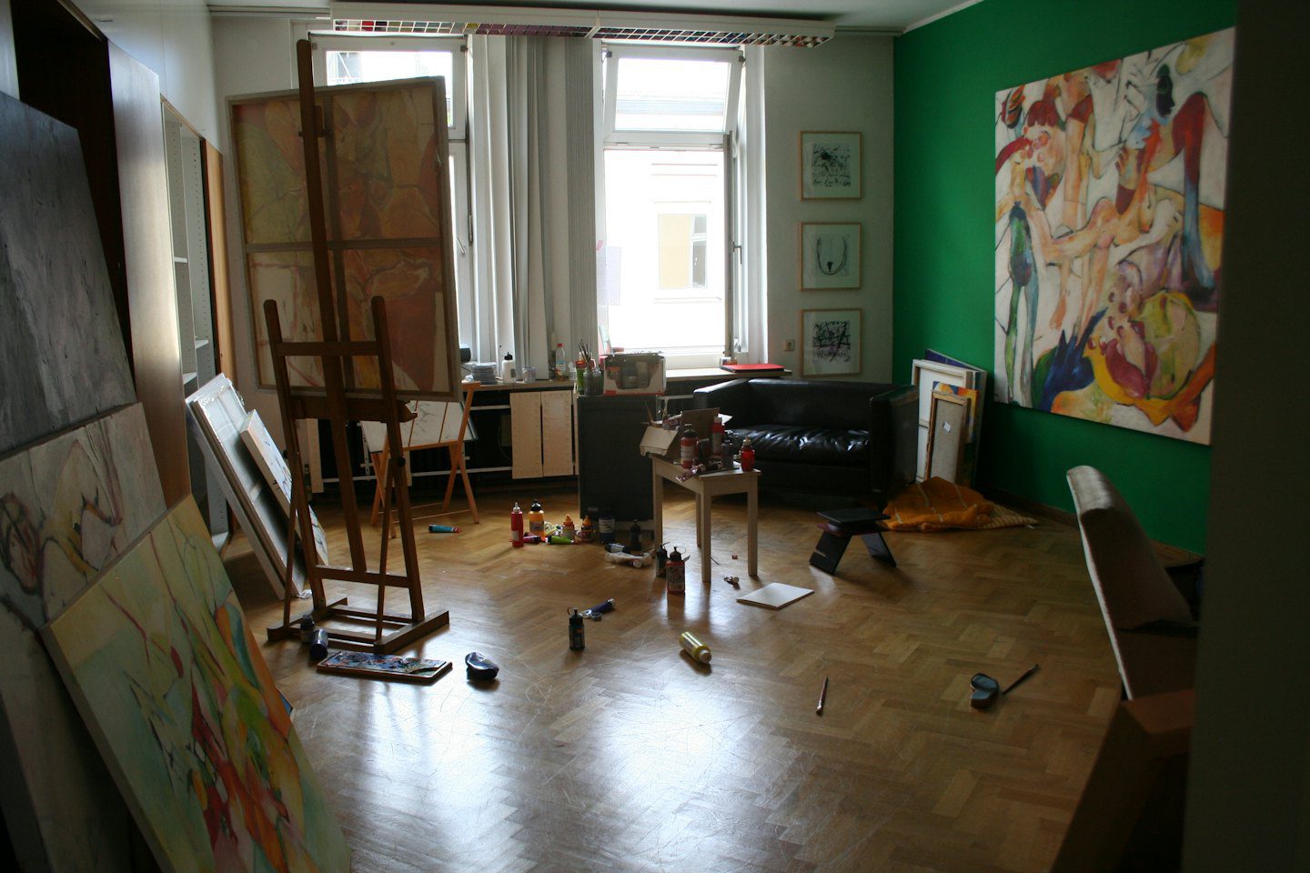 Estudio de artista con lienzos, caballetes y materiales.